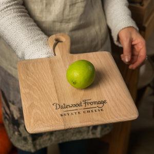Rustic wooden serving board made of natural wood with unique grain patterns, perfect for serving cheese, fruits, and charcuterie.